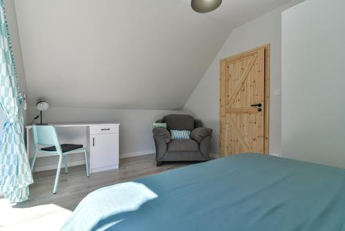 a bedroom with a bed and a desk and a chair at Domki z Pasją in Kopalino