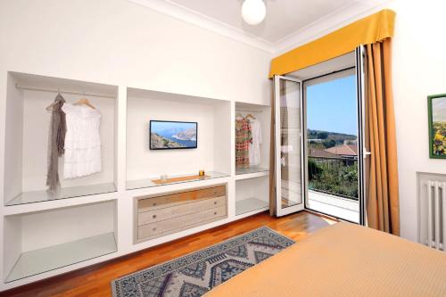 a bedroom with white walls and a large sliding glass door at Residenza Villa Titina in SantʼAgata sui Due Golfi