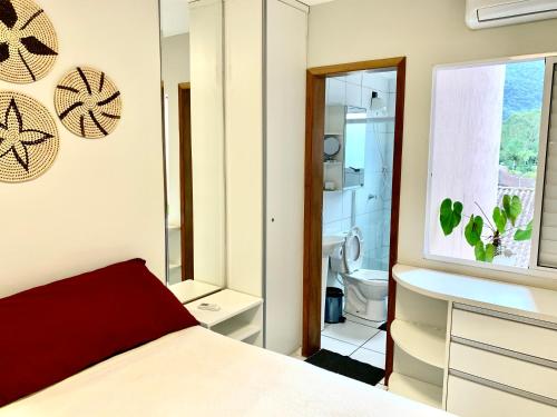 a bedroom with a bed and a bathroom at Apto Ubatuba home - Centro c vista in Ubatuba