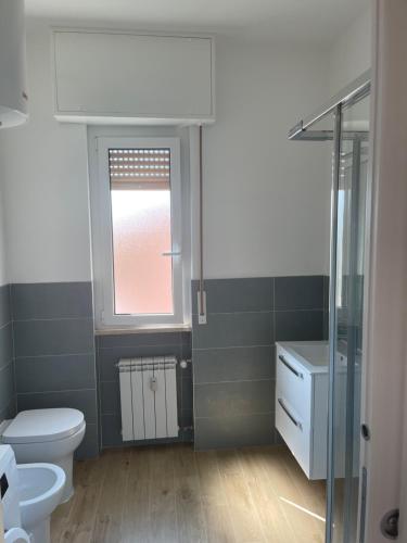 a bathroom with a toilet and a window at CASA SVEVA PIETRA LIGURE in Pietra Ligure
