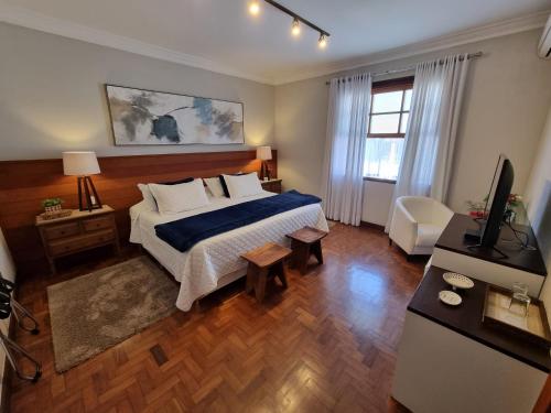 a bedroom with a bed and a television in it at Saison Resort & Spa in Itaipava