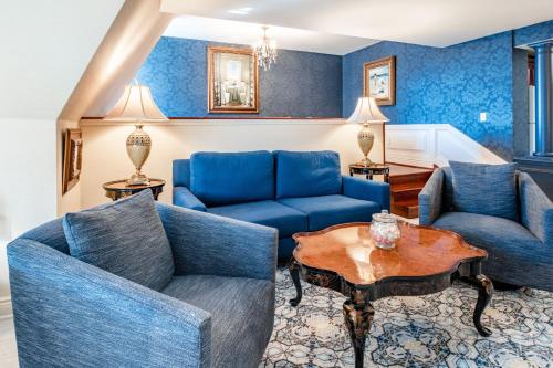 a living room with blue couches and a table at Red Coach Inn in Niagara Falls