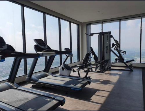 a gym with cardio equipment in a building with windows at Hilton Hill10 Shah Alam in Shah Alam