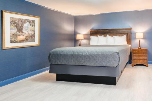 a bedroom with a bed and a painting on the wall at Red Coach Inn in Niagara Falls