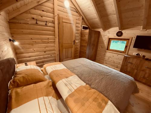 sypialnia w drewnianym domku z łóżkiem i telewizorem w obiekcie Wooden Corner w mieście Kolašin