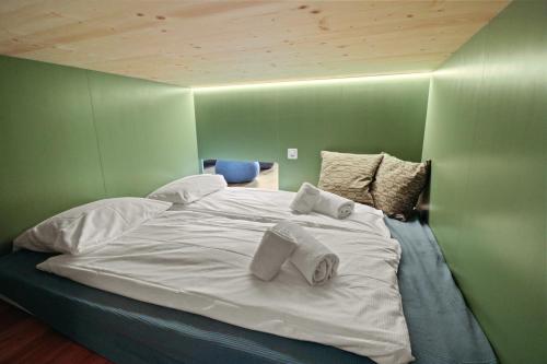a bedroom with a large white bed with towels on it at Superbe appartement avec piscine in Nendaz