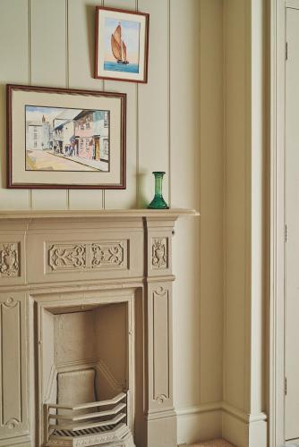 a living room with a fireplace and a picture on the wall at Harold House in Cowes