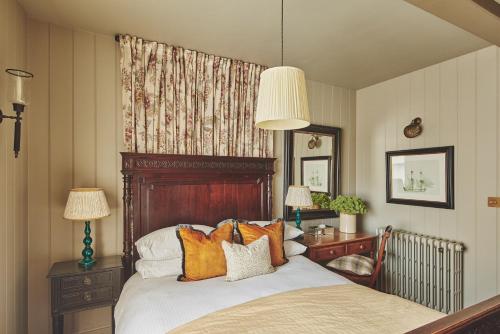 um quarto com uma cama grande e almofadas laranja em Harold House em Cowes