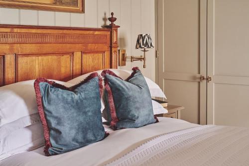 a bed with two blue pillows on it at Harold House in Cowes