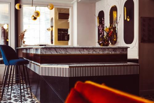 a bar in a restaurant with chairs and a mirror at Hotel Panache in Paris
