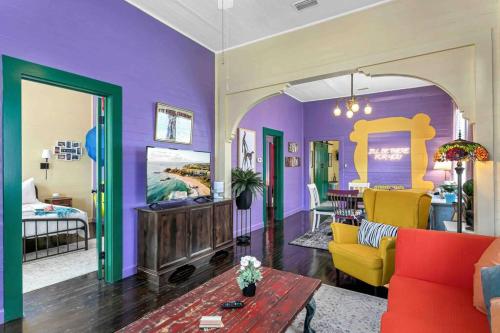 a living room with purple walls and yellow furniture at FRIENDS AIRBNB Themed 2bed 2bath walkable to all of Ybor in Tampa