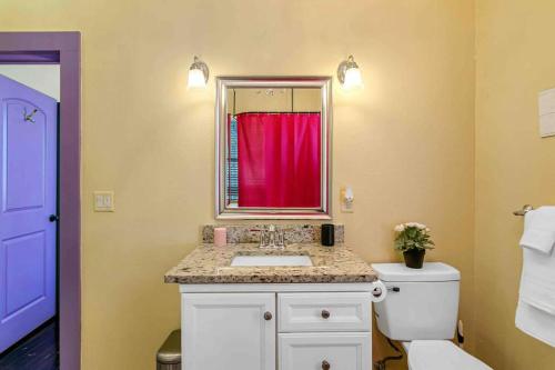 baño con lavabo y cortina roja en FRIENDS AIRBNB Themed 2bed 2bath walkable to all of Ybor en Tampa