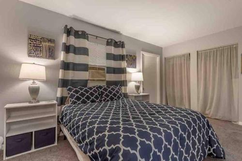 1 dormitorio con 1 cama con edredón azul y blanco en Alberts Abode Prime Brandon location Walkable, en Brandon