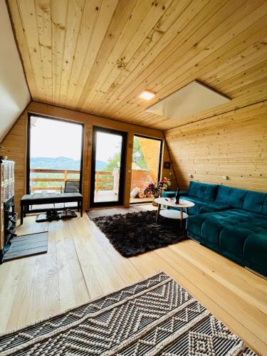 a living room with a green couch and a table at CABANA 365 in Braşov