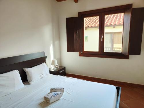 a bedroom with a white bed with a phone on it at Albis Harena - Porto Antigo 2 in Santa Maria
