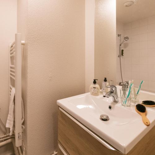 a bathroom with a white sink and a mirror at Cerise Valence in Valence