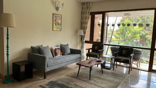 a living room with a couch and a large window at LUHO Grande in Bengaluru