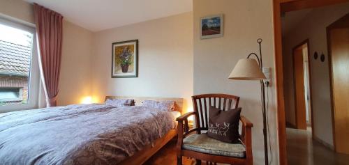1 dormitorio con cama, lámpara y silla en Ferienwohnung Ünnern Appelboom, en Schneverdingen