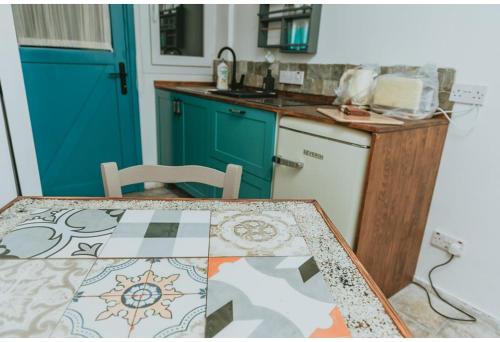 a kitchen with a table and a blue door at Sunside Inn Hotel in Kérynia