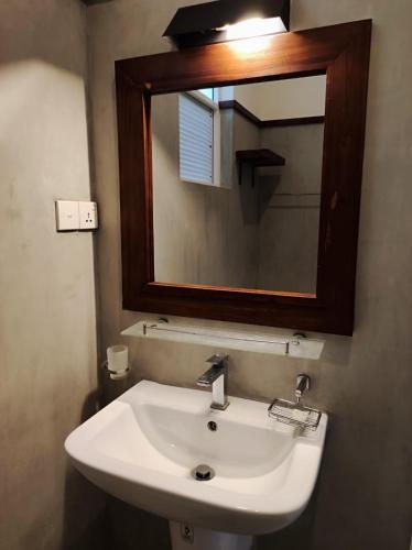 a bathroom with a white sink and a mirror at Nil Diya Beach Resort in Matara