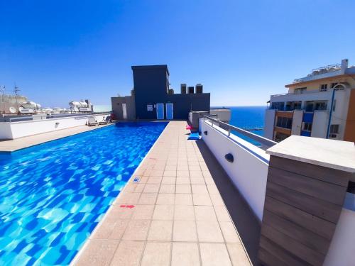 a swimming pool on the roof of a building at Eden Sea Breeze, 1 bed, Rooftop Pool, Gym in Limassol