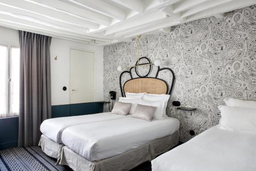 パリにあるホテル パナシェのベッド2台と壁が備わるホテルルームです。