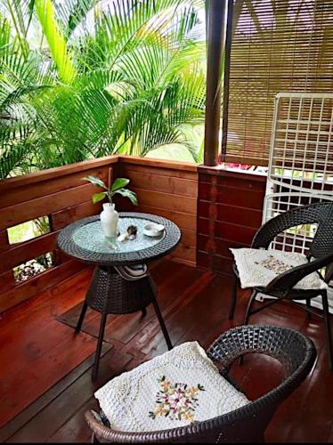 a patio with a table and chairs and a window at LA CASE BOIS CRÉOLE in Albion