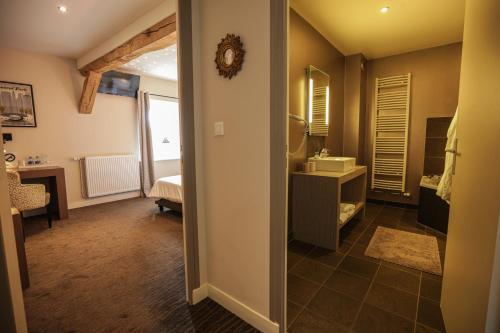 een badkamer met een wastafel en een spiegel bij Ferme du Roy in Anserville