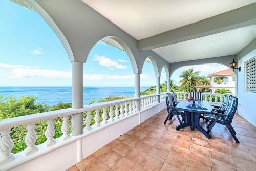 a balcony with a table and chairs overlooking the ocean at Caribbean Sea View Holiday Apartments in Méro