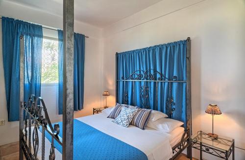 1 dormitorio con 1 cama con cortinas azules en Caribbean Sea View Holiday Apartments en Méro