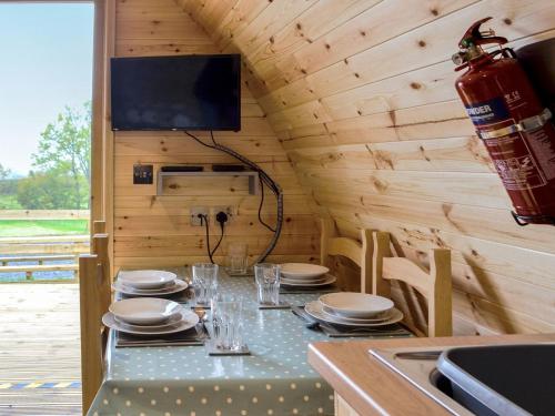 a dining room with a table in a wooden cabin at Castle View Glamping in Llanbister