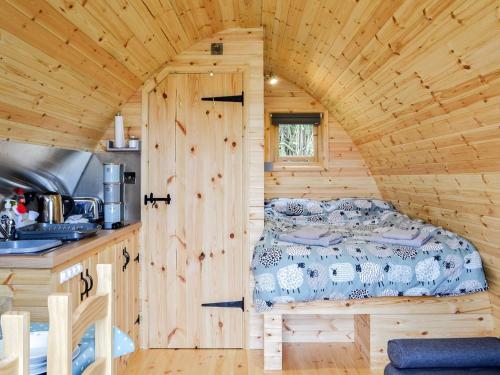 a bedroom with a bed in a wooden cabin at Castle View Glamping in Llanbister