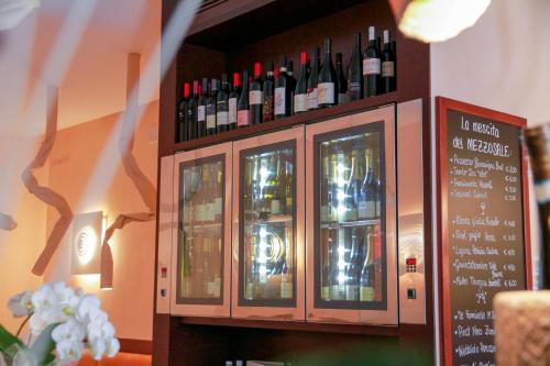 科內利亞諾的住宿－Locanda Mezzosale，酒吧里的一瓶葡萄酒