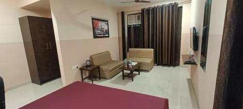uma sala de estar com duas cadeiras e uma televisão em Mi Casa Sector 47 em Gurgaon