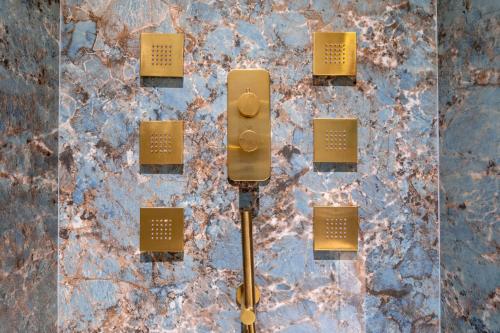 a yellow light on a stone wall with yellow chargers at Grand Hotel Kalamata in Kalamata