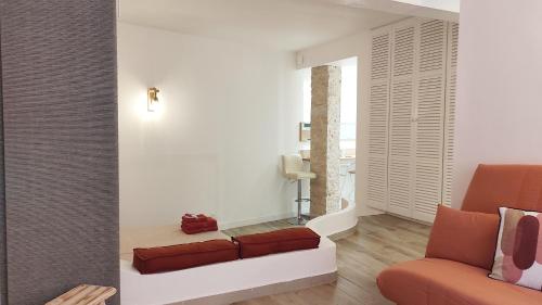 a living room with a couch and a chair at Bastia F1 type loft plein centre, calme, clim, refait à neuf et à 200m du port in Bastia