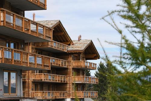 ein großes Holzgebäude mit Balkon in der Unterkunft Aiguilles Rouges - Tête Blanche - Thermes de la Dixence in Hérémence