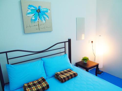 Una cama azul con dos almohadas encima. en The Cardamom Hostel, en Melaka