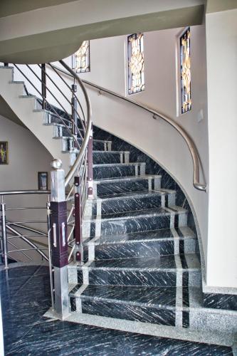 a spiral staircase in a house with black marble floors at Traditional Hotel & Restaurant !! Kurseong !! Best Hotel in Kurseong in Darjeeling