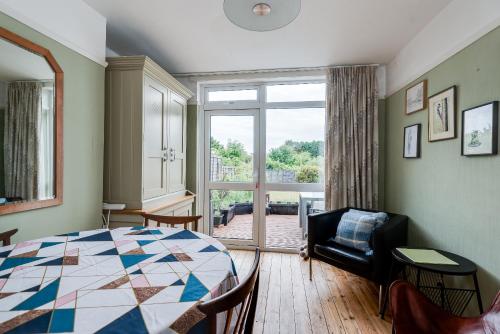 Cheerfull 3-Bedroom Home with parking & garden في أوكسفورد: غرفة نوم مع سرير وغرفة معيشة مع نافذة
