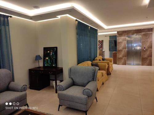 a living room with a couch and chairs and a table at Black Iris Hotel II in Madaba