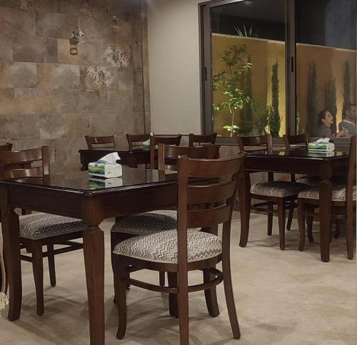 a dining room with a wooden table and chairs at Black Iris Hotel II in Madaba