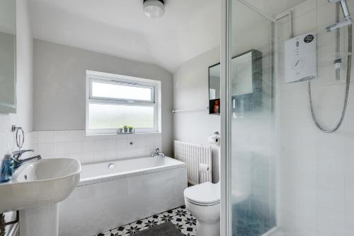 een badkamer met een wastafel, een toilet en een douche bij Cheerfull 3-Bedroom Home with parking & garden in Oxford