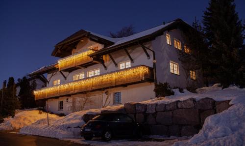 une maison avec une voiture garée devant elle dans la neige dans l'établissement Hirsch-Lounge, à Höchenschwand