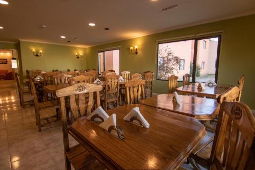 349 Suites في إل كالافاتي: غرفة طعام مع طاولات وكراسي خشبية