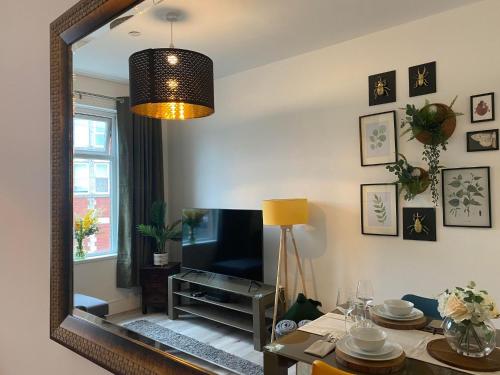 a mirror reflecting a living room with a table and a television at The Retreats 1 Kenfig Hill Pet Friendly 2 Bedroom Flat with King Size bed twin beds and sofa bed sleeps up to 5 people in Kenfig Hill