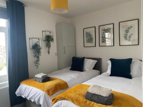 two beds sitting next to each other in a room at The Retreats 1 Kenfig Hill Pet Friendly 2 Bedroom Flat with King Size bed twin beds and sofa bed sleeps up to 5 people in Kenfig Hill