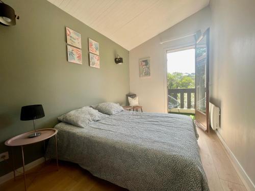 1 dormitorio con cama y ventana en Maison chaleureuse sous les pins, en Seignosse