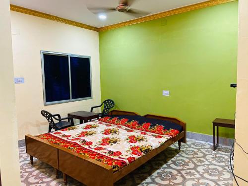 a bedroom with a bed with red flowers on it at Hotel Nishi Pvt ltd in Balasore