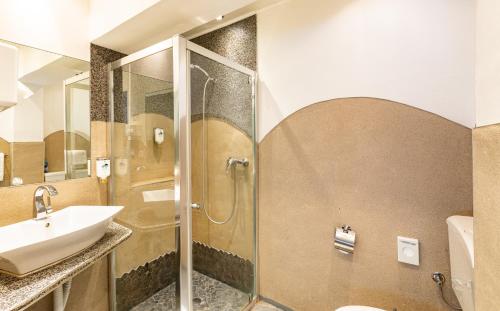 a bathroom with a sink and a shower at Stadt-gut-Hotel Großer Kurfürst in Emden